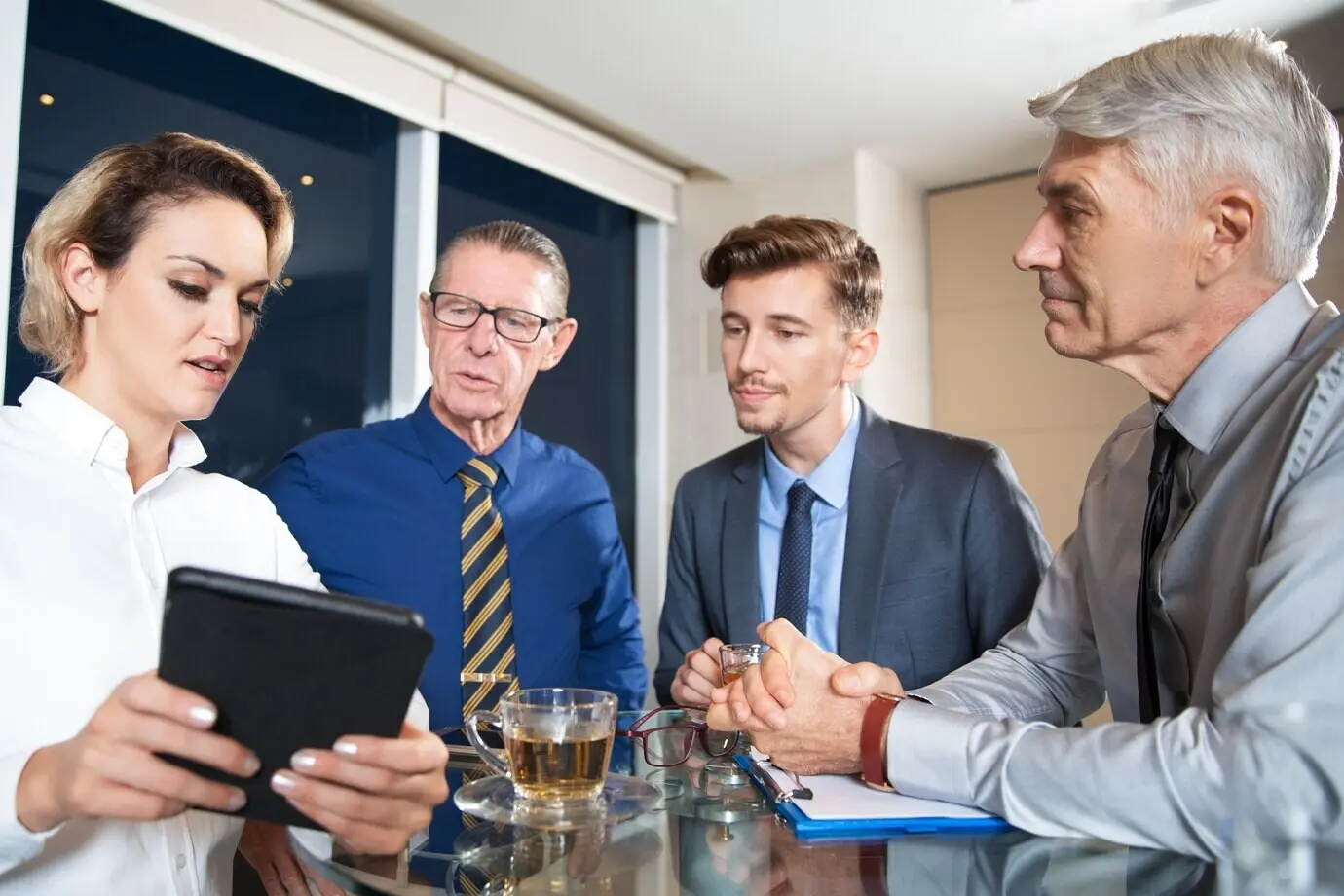 Geschäftsleute treffen sich im Café und nutzen ein Tablet.